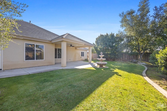 view of yard with ceiling fan and a patio