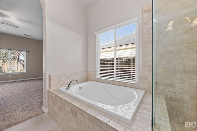 bathroom featuring tile patterned flooring and tiled tub