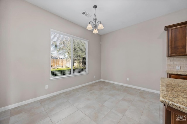 unfurnished dining area featuring light tile patterned flooring and a notable chandelier