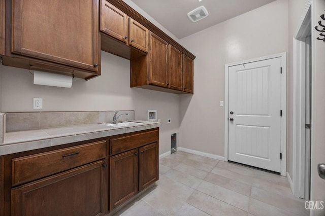 kitchen with light tile patterned floors, tile counters, and sink