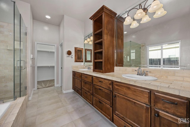 bathroom featuring tile patterned flooring, vanity, separate shower and tub, and a notable chandelier