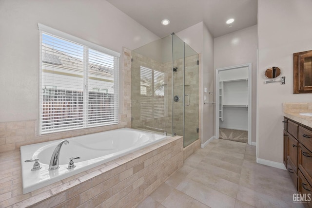 bathroom with shower with separate bathtub, tile patterned floors, and vanity