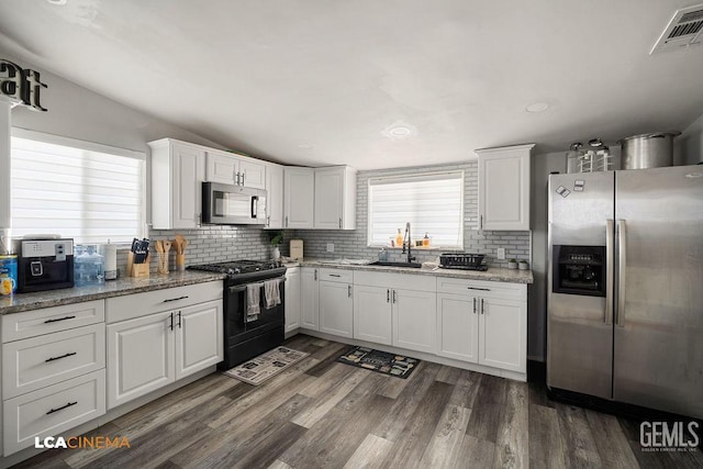 4620 Taft Hwy, Bakersfield, CA 93313 - kitchen featuring appliances with stainless steel finishes, tasteful backsplash, white cabinetry, dark wood-style flooring, and light stone counters