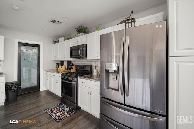 4620 Taft Hwy, Bakersfield, CA 93313 - kitchen featuring appliances with stainless steel finishes, dark wood finished floors, white cabinets, light stone counters, and decorative backsplash