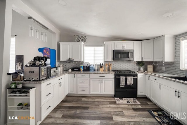 4620 Taft Hwy, Bakersfield, CA 93313 - kitchen featuring black gas range, stainless steel microwave, backsplash, white cabinets, and lofted ceiling
