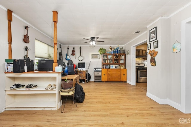 kitchen with visible vents, crown molding, ceiling fan, wood finished floors, and stainless steel gas range oven