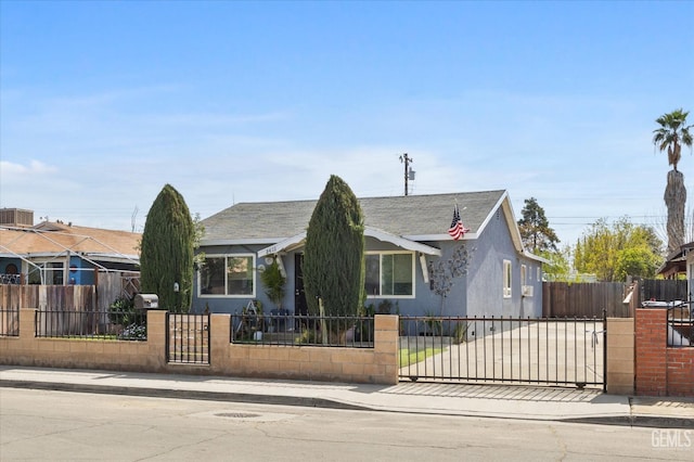 view of front of house with central AC unit, a gate, a fenced front yard, and stucco siding