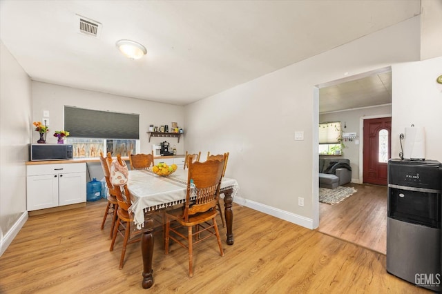 dining room featuring baseboards, light wood-style floors, and visible vents