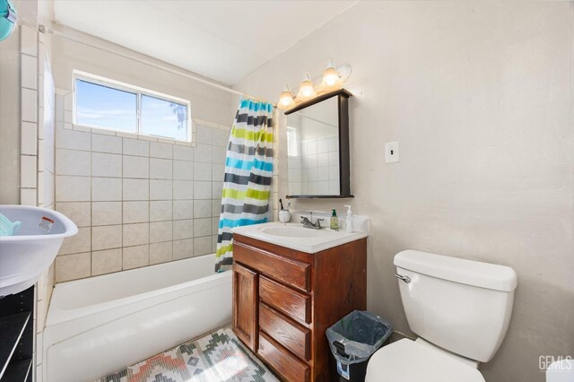 bathroom featuring shower / tub combo with curtain, toilet, and vanity