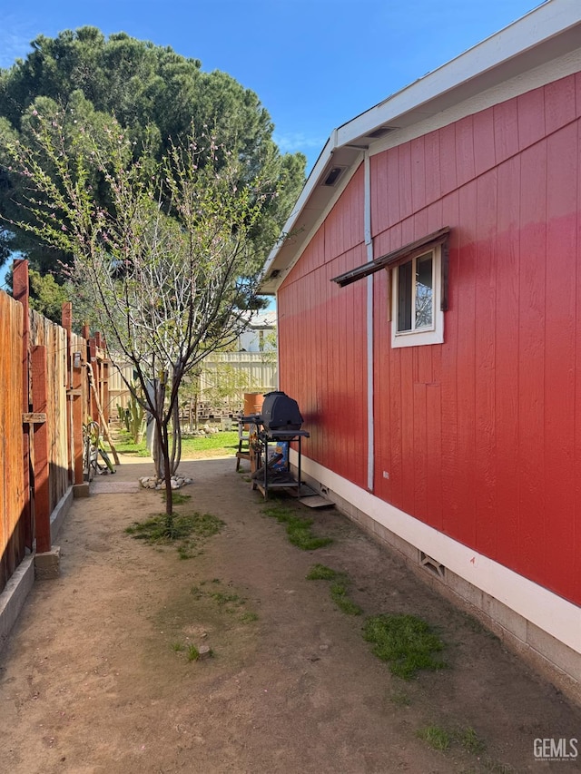 view of side of property with crawl space and fence