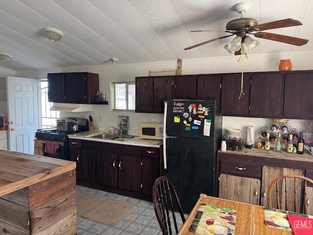 kitchen featuring ceiling fan, under cabinet range hood, light countertops, black appliances, and a sink