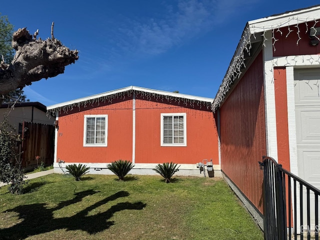 view of side of property featuring a yard and fence