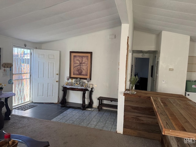 entryway with lofted ceiling, carpet, and tile patterned floors