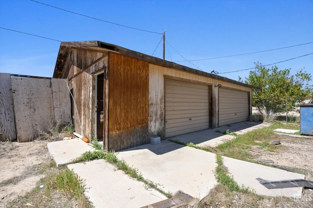 detached garage featuring fence