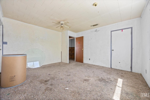 spare room with carpet flooring, visible vents, and a ceiling fan