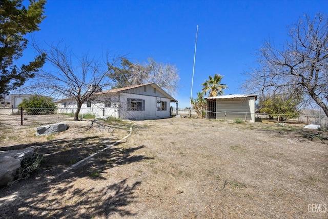 exterior space featuring an outbuilding and fence