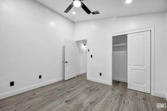 unfurnished bedroom with ceiling fan, light wood-type flooring, and a closet