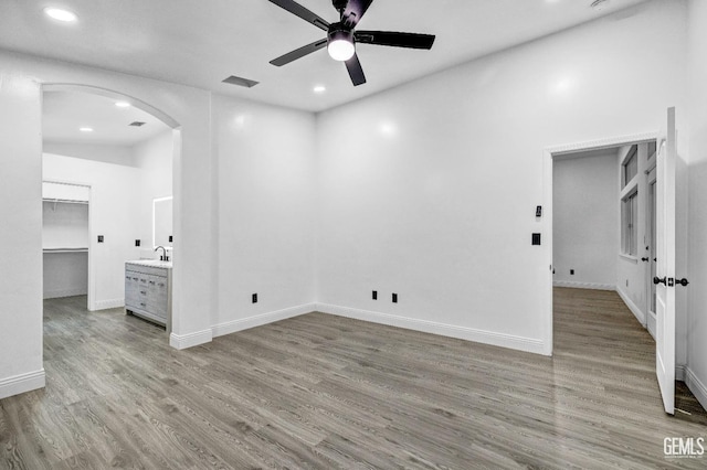 spare room featuring ceiling fan, sink, and light hardwood / wood-style floors