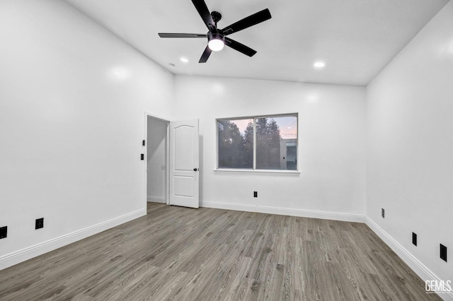 empty room featuring ceiling fan, vaulted ceiling, and light hardwood / wood-style flooring