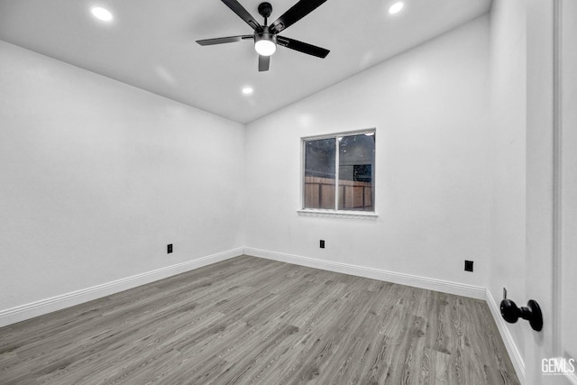 empty room with lofted ceiling, light hardwood / wood-style floors, and ceiling fan