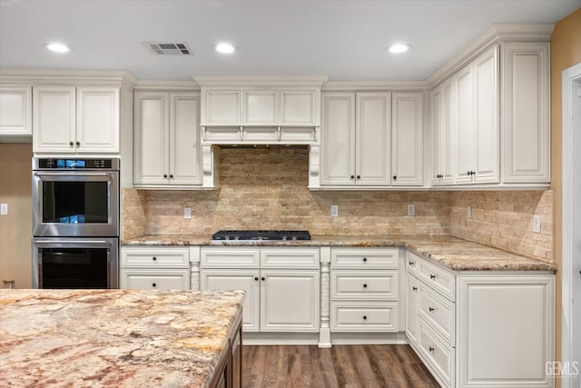 kitchen featuring white cabinetry, gas cooktop, stainless steel double oven, and light stone counters