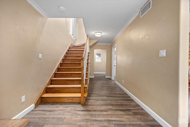 stairs featuring ornamental molding and hardwood / wood-style floors