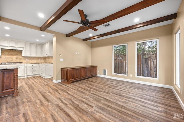 unfurnished living room with beam ceiling, ceiling fan, and light hardwood / wood-style floors