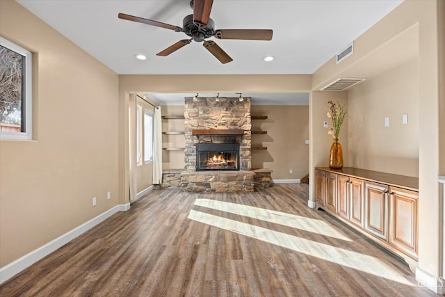 unfurnished living room featuring a stone fireplace, ceiling fan, and light wood-type flooring