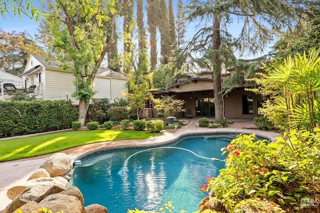 view of swimming pool featuring a lawn