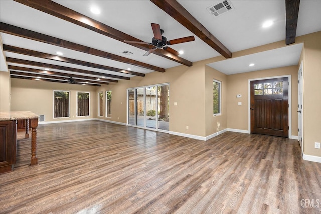 unfurnished living room with hardwood / wood-style flooring, ceiling fan, and beam ceiling