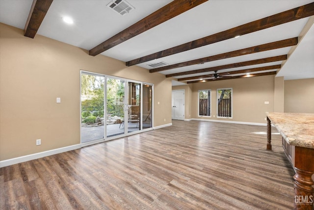 unfurnished living room featuring beamed ceiling, wood-type flooring, and ceiling fan