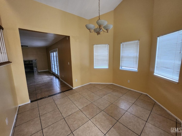 5913 El Camino Ave, Bakersfield, CA 93313 - spare room with light tile patterned floors, a chandelier, plenty of natural light, and high vaulted ceiling