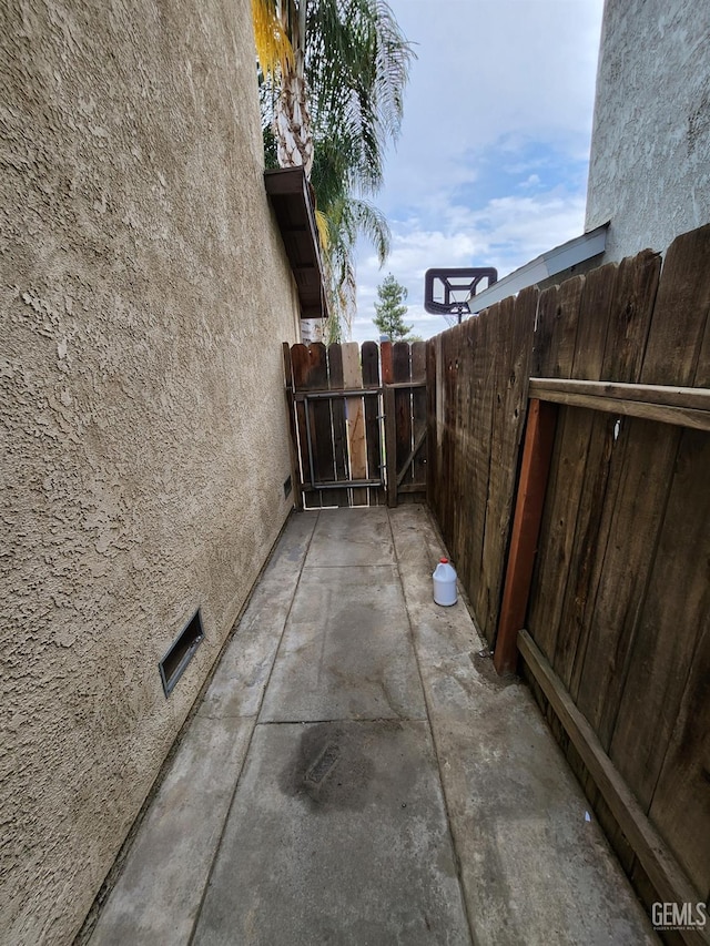 5913 El Camino Ave, Bakersfield, CA 93313 - view of side of home featuring stucco siding, fence, a gate, and a patio
