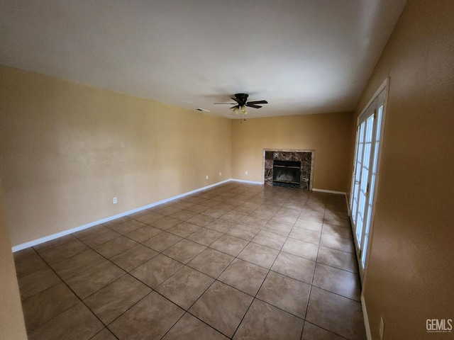 5913 El Camino Ave, Bakersfield, CA 93313 - unfurnished living room featuring a ceiling fan, tile patterned flooring, a premium fireplace, and baseboards