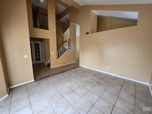 5913 El Camino Ave, Bakersfield, CA 93313 - empty room featuring tile patterned flooring, stairway, baseboards, and high vaulted ceiling