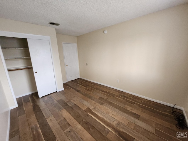 5913 El Camino Ave, Bakersfield, CA 93313 - unfurnished bedroom featuring dark wood-type flooring, baseboards, a closet, and a textured ceiling