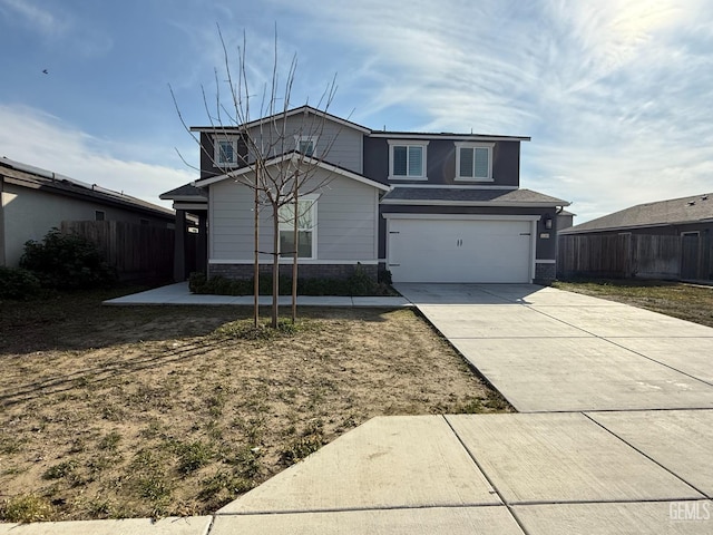 view of front of home with driveway, an attached garage, and fence