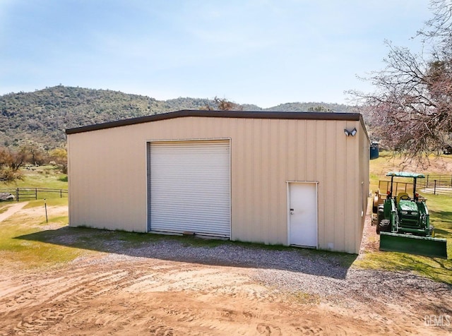 detached garage with a mountain view and fence