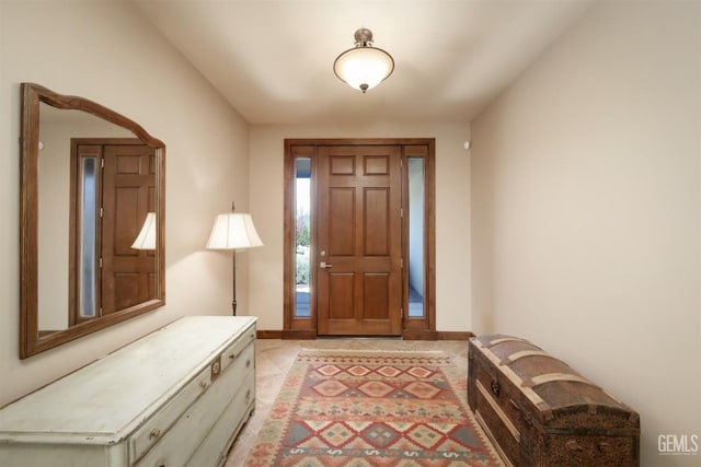 foyer with light tile patterned flooring and baseboards