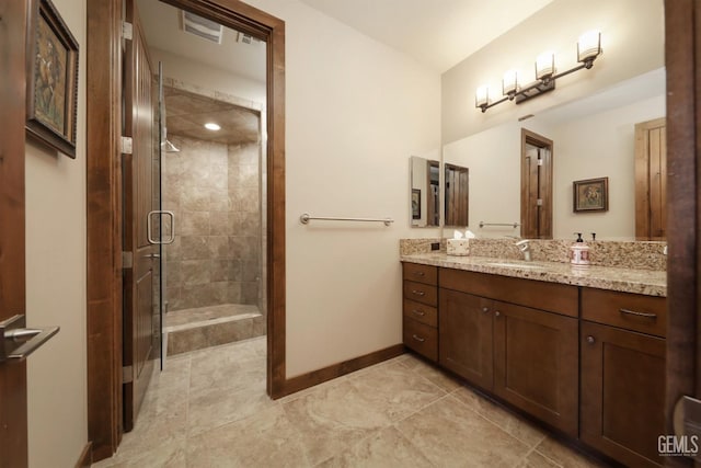 bathroom with baseboards, a shower stall, tile patterned floors, and vanity