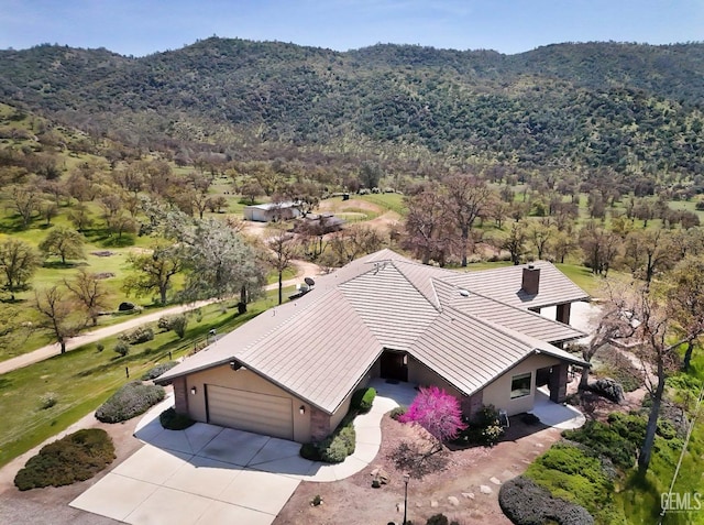 drone / aerial view with a wooded view and a mountain view