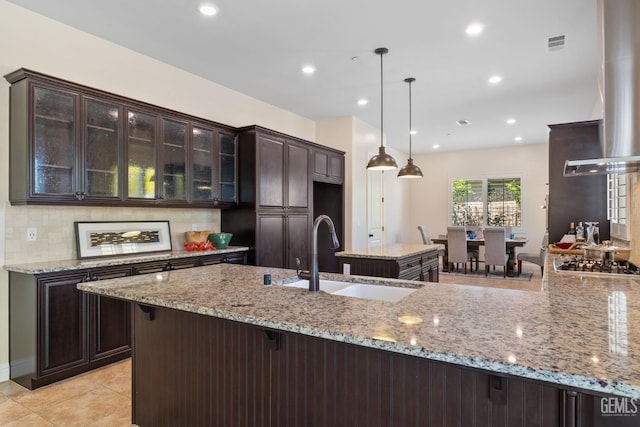 14822 Plumeria Ct, Bakersfield, CA 93314 - kitchen with a sink, dark brown cabinets, stainless steel gas cooktop, decorative backsplash, and light stone countertops