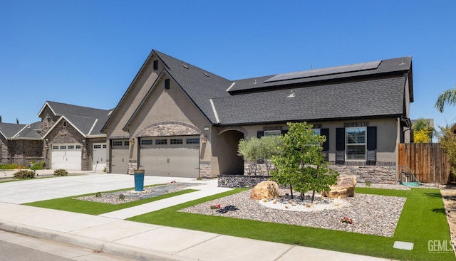 14822 Plumeria Ct, Bakersfield, CA 93314 - view of front of home with stone siding, solar panels, a garage, and stucco siding