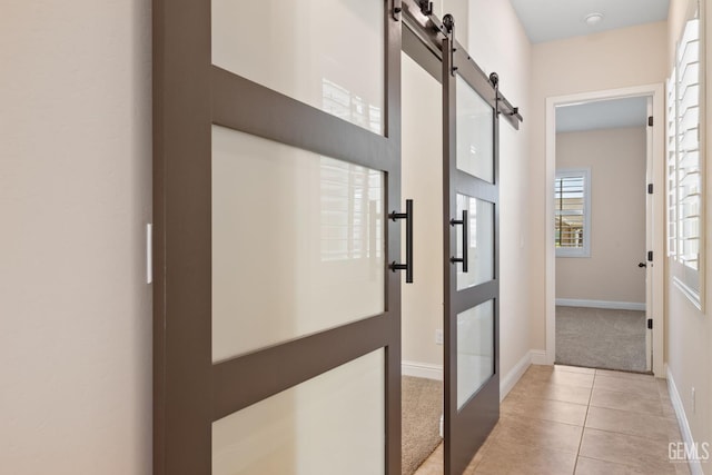 14822 Plumeria Ct, Bakersfield, CA 93314 - corridor with a barn door, baseboards, light carpet, and light tile patterned flooring