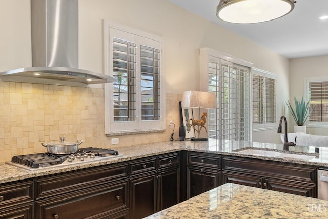 14822 Plumeria Ct, Bakersfield, CA 93314 - kitchen featuring wall chimney exhaust hood, stainless steel gas stovetop, a sink, and light stone counters
