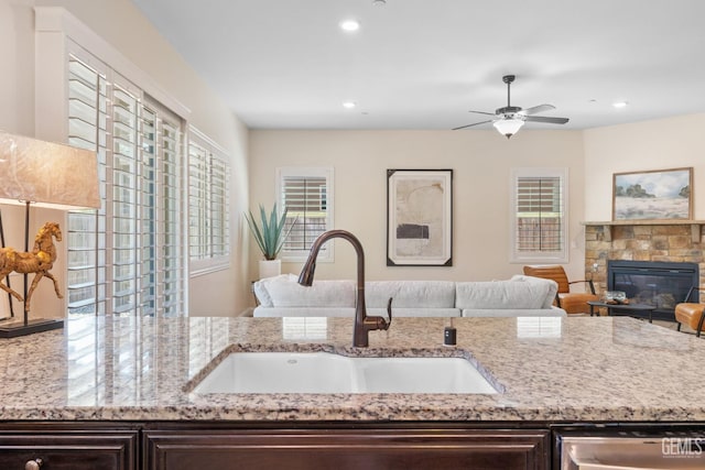 14822 Plumeria Ct, Bakersfield, CA 93314 - kitchen with a sink, stainless steel dishwasher, dark brown cabinets, light stone countertops, and recessed lighting
