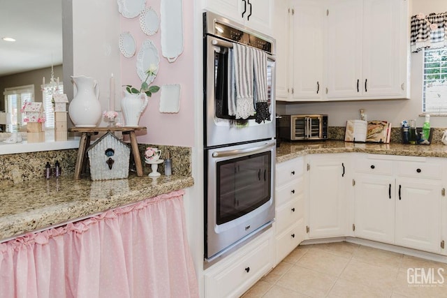 7116 Jolynn St, Bakersfield, CA 93308 - kitchen featuring double oven, white cabinetry, light tile patterned flooring, and light stone counters