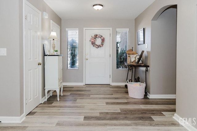7116 Jolynn St, Bakersfield, CA 93308 - entrance foyer with arched walkways, light wood-type flooring, and baseboards