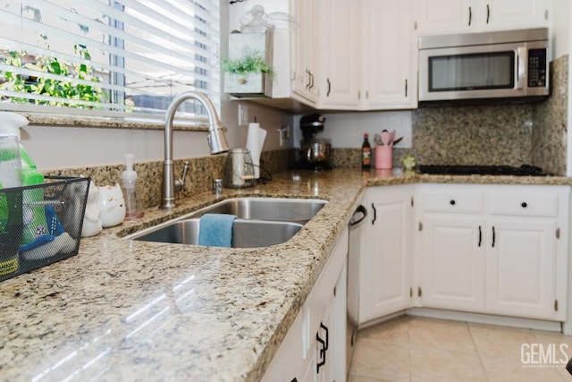 7116 Jolynn St, Bakersfield, CA 93308 - kitchen featuring stainless steel microwave, a sink, light tile patterned floors, and light stone counters