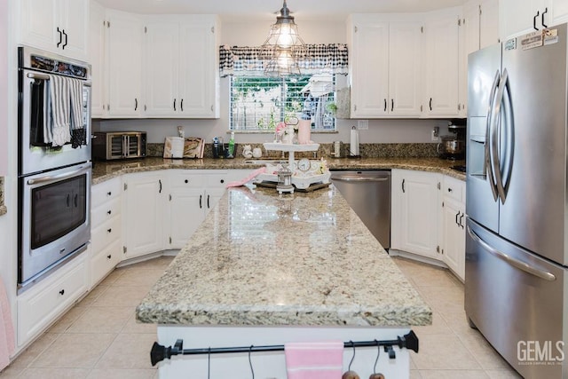 7116 Jolynn St, Bakersfield, CA 93308 - kitchen featuring appliances with stainless steel finishes, a center island, white cabinets, and light tile patterned floors